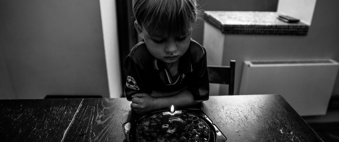 L’association Face à l’Inceste lance une campagne de sensibilisation et une pétition pour instaurer la présomption d'absence de consentement de l'enfant dans la loi Photo en noir et blanc, d'un enfant assis seule, devant un gateau, avec une bougie pour ses 5 ans