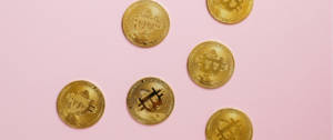 Des bitcoins sur un fond rose