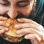 Un homme qui mange un burger