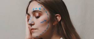 Une femme avec du crayon sur le visage comme avant une opération chirurgicale
