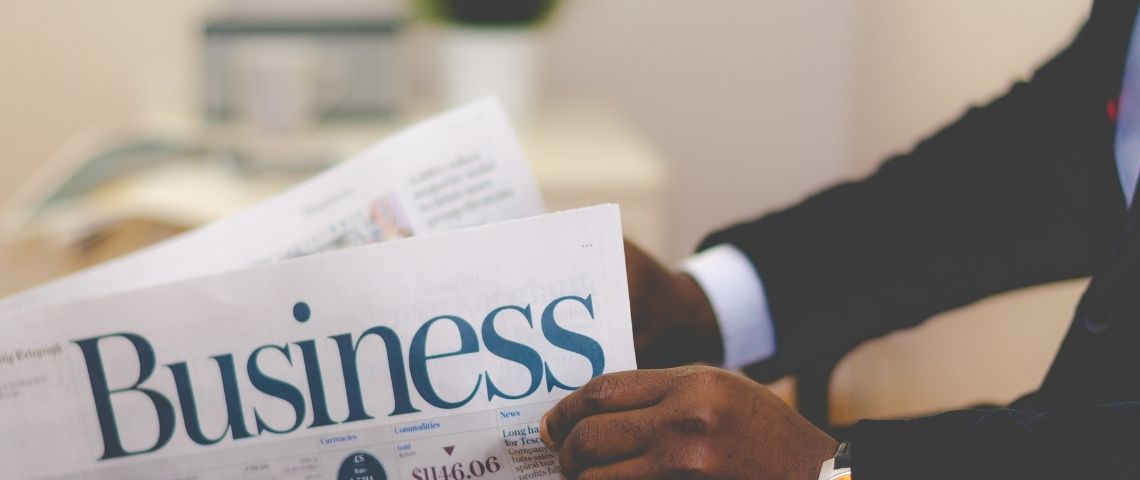Deliveroo annonce une levée de fonds de 180 millions de dollars avant une possible entrée en bourse Jeune homme lisant un journal business