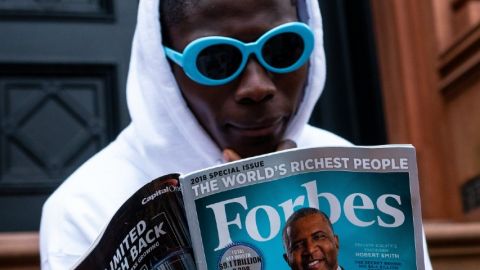 Jeune homme en train de lire un numéro du magazine Forbes