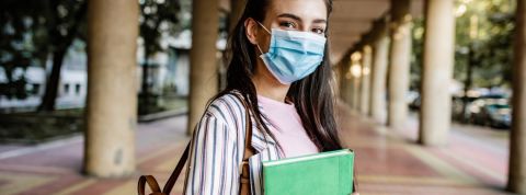 Comment les 20% des gens les plus diplômés façonnent la société ? Une jeune femme portant un masque dans les couloirs d'une université