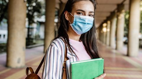 Une jeune femme portant un masque dans les couloirs d'une université