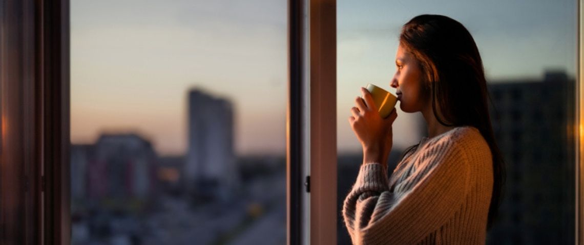 Comment les chefs d’entreprises peuvent accompagner leurs collaborateurs dans la mutation des modes de travail Une femme boit son café à la fenêtre