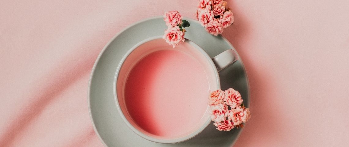 Le boom des boissons relaxantes Une tasse avec un liquide rose et des fleurs roses