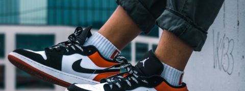StockX, le site qui veut transformer la GenZ en traders Un garçon porte une paire de Nike, buildings en fond