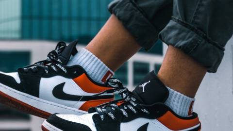 Un garçon porte une paire de Nike, buildings en fond