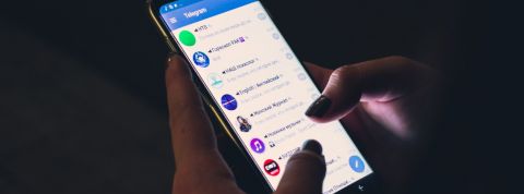 Fronde contre WhatsApp : quelles sont les alternatives ? gros plan d'une femme utilisant Telegram sur son smartphone