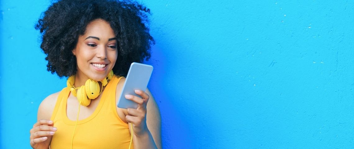 Les nouvelles pratiques social ads en 2021 : comment éviter une hausse des coûts ? Une femme avec un téléphone dans les mains