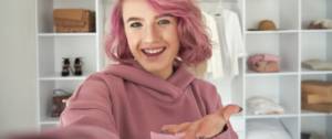 Une adolescente avec les cheveux roses en train de faire du live shopping