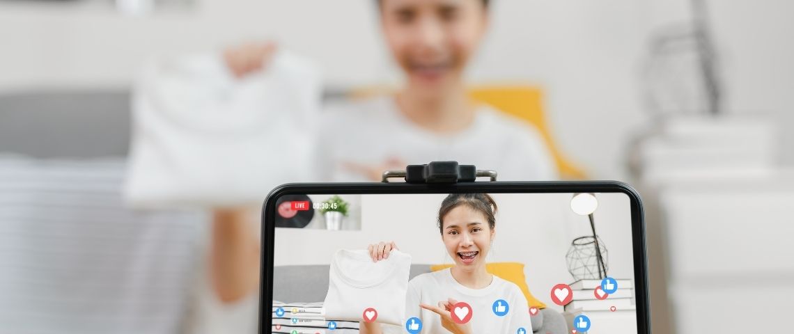 L’agence Heaven propose une nouvelle offre : le Live Shopping , du téléachat 2.0… ou presque Jeune fille prsentant un T-shirt à sa communauté, qui like en retour