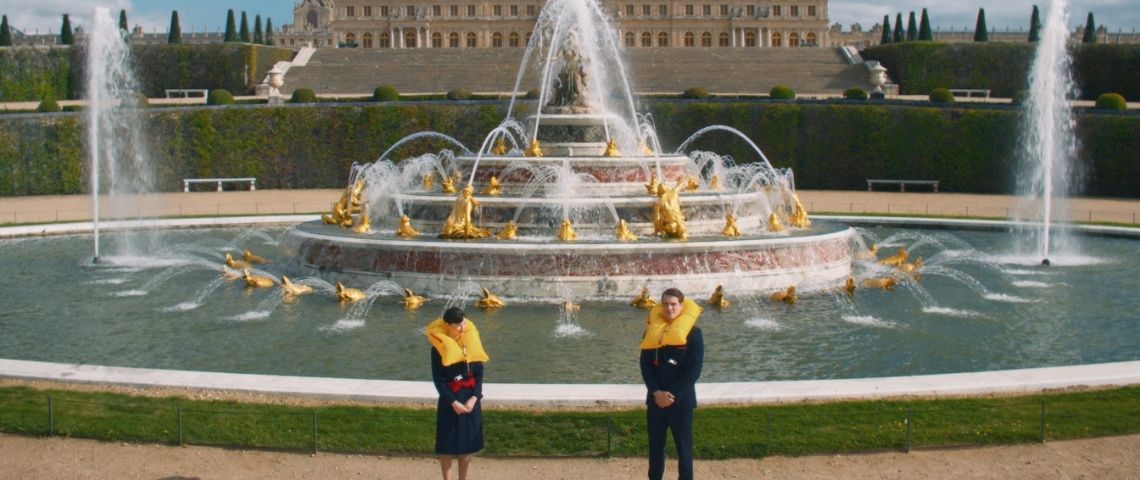 Air France dévoile en avant-première son nouveau film de consignes de sécurité à bord, un véritable concentré de culture française, élégant, vivant et tout en mouvement. Une hotesse de l'air et un steward devant les fintaines du château de Versailles