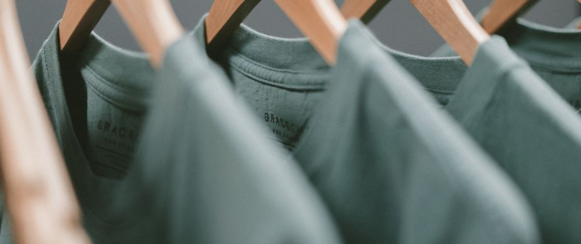 Kaana aide les créateurs de mode à trouver des fournisseurs éthiques, de l’atelier jusqu’à la sélection des tissus. T-shirt verts sur des cintres