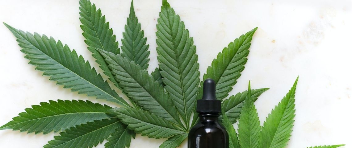 Boiron s'associe avec Emmac Life Sciences pour une expérimentation sur le cannabis thérapeutique en France Feuille de cannabis avec une petite fiole d'huiles essentielles sur le devant de l'image
