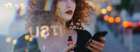 Comment les business illégaux s'organisent sur TikTok ? Une femme tenant un smartphone et une cigarette électronique