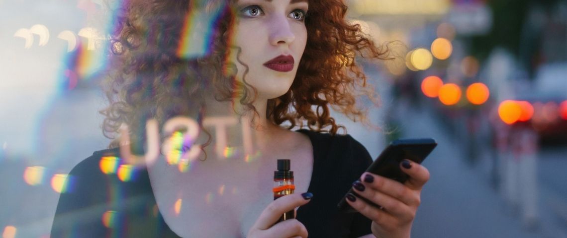 Comment les business illégaux s'organisent sur TikTok ? Une femme tenant un smartphone et une cigarette électronique