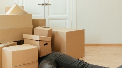 Une personne en dessous de nombreux colis