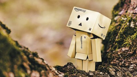 petit personnage triste composé de cartons amazon