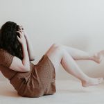 femme de profil, au sol, se prenant la tête entre les mains