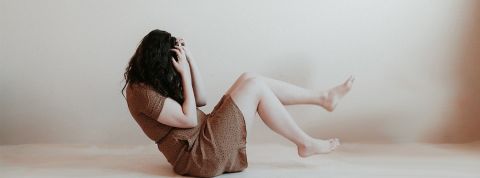 Priscilla-du-Preez femme de profil, au sol, se prenant la tête entre les mains