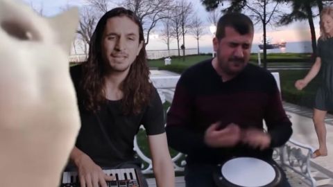 Un chat et deux hommes faisant de la musique