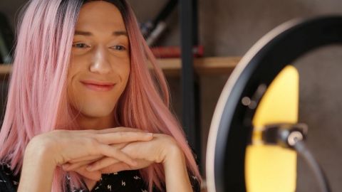 Une femme avec des cheveux roses devant une ring light TikTok