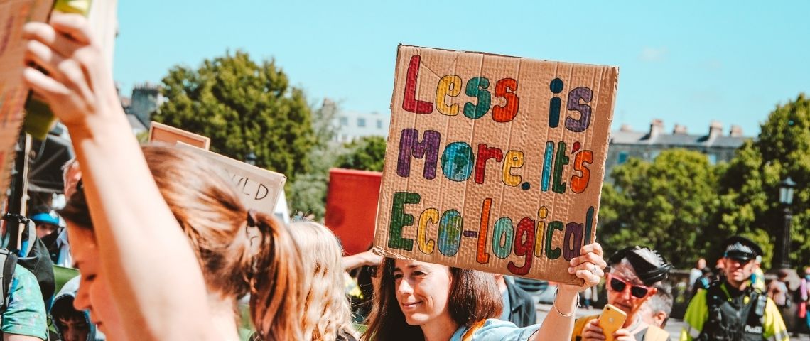 Lancée à l’initiative des fondateurs du collectif et de la newsletter Tech Trash, Climax s’attelle à la crise climatique et aux multiples tentatives de greenwashing qui en découlent. Manifestation, avec une jeune fille tenant une affiche - Less is more, It's eco-logical -