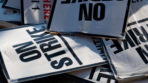 Des panneaux  - on strike -  entassés sur le bitume