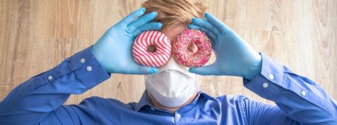 Qu'est-ce que le vaccine marketing ? Un homme masqué et ganté tenant deux donuts devant ses yeux