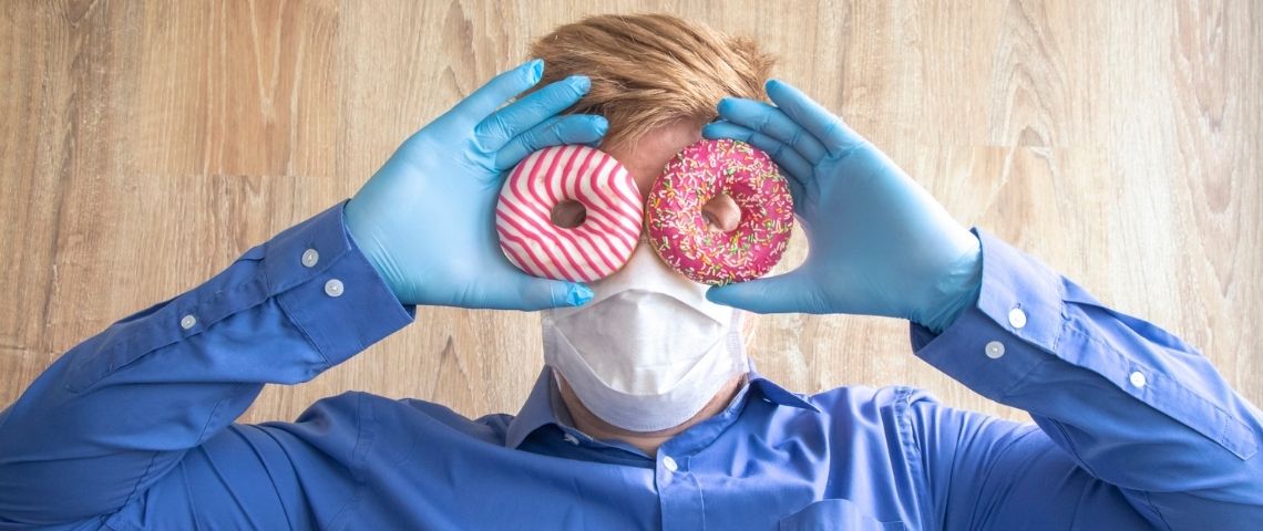 Qu'est-ce que le vaccine marketing ? Un homme masqué et ganté tenant deux donuts devant ses yeux