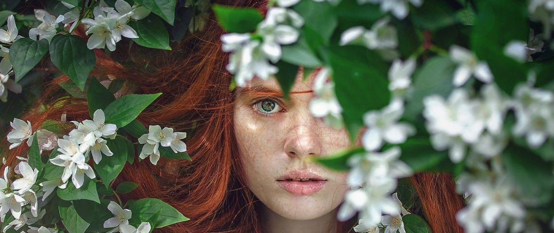 Tous les produits Garnier, au niveau mondial, sont à présent officiellement certifiés par Cruelty Free International après avoir obtenu l'aval du programme Leaping Bunny de Cruelty Free International Jeune femme rousse apparaissant dans des feuilles vertes et des fleurs blanches