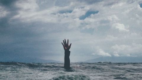 Main sortant de la mer d'une personne se noyant