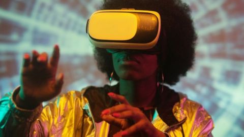 Comment fonctionne la réalité augmentée ? Une jeune femme noire portant un casque de réalité virtuelle sur un fond psychédélique