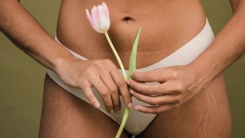 Une femme en culotte qui tient une tulipe