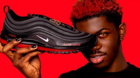Les Satan Shoes de MSCHF Lil Nas X tenant une chaussure  - Satan -  de MSCHF