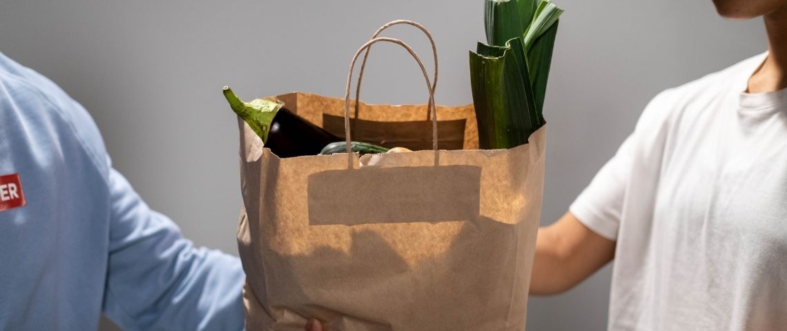 Publicis Conseil invite tous les acteurs de la chaîne de solidarité sont invités à rejoindre l’initiative Solidarité Associations pour faire face à la crise. Personne donnant un sac de nourriture à une autre personne