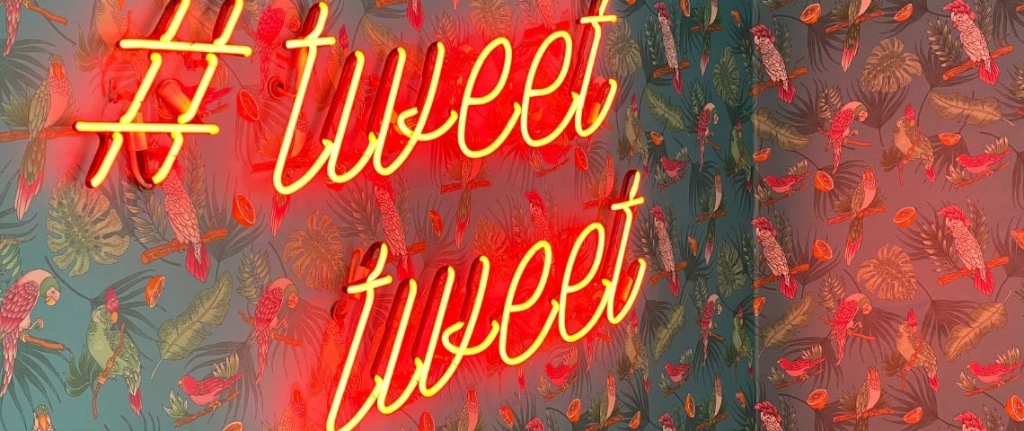 Qu'est-ce que le clout mining ? Un mur avec du papier peint et des néons rouges indiquant - tweet tweet -