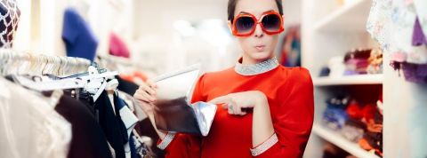 Pourquoi le vintage n'attire pas les classes populaires ? Une femme en train d'ouvrir son portefeuille dans une friperie