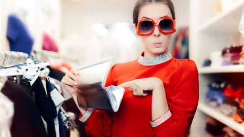 Une femme en train d'ouvrir son portefeuille dans une friperie