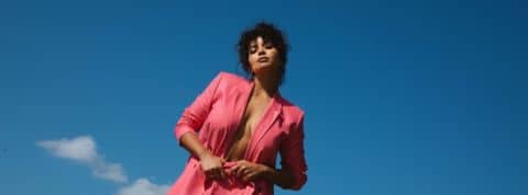 Quelle est la stratégie de Balzac Paris ? Une jeune femme en tailleur rose devant le ciel