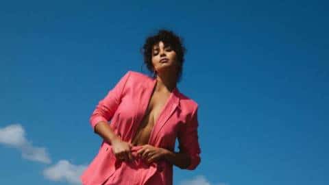 Une jeune femme en tailleur rose devant le ciel