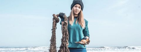 jeune fille qui sort des déchets de la mer