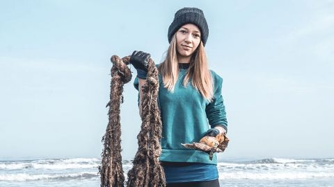 jeune fille qui sort des déchets de la mer