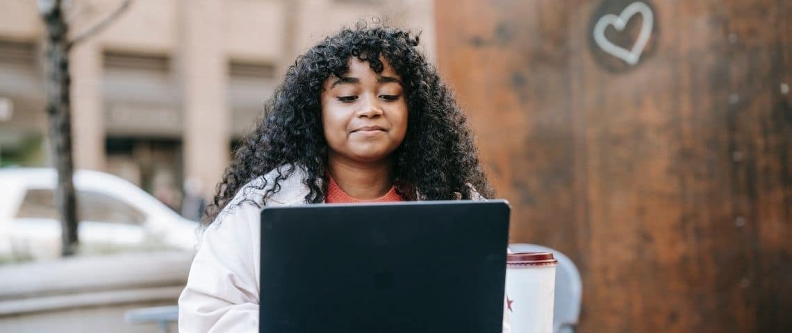 LEMON-ATTRACTIVE Une jeune femme qui sourit devant son écran d'ordinateur
