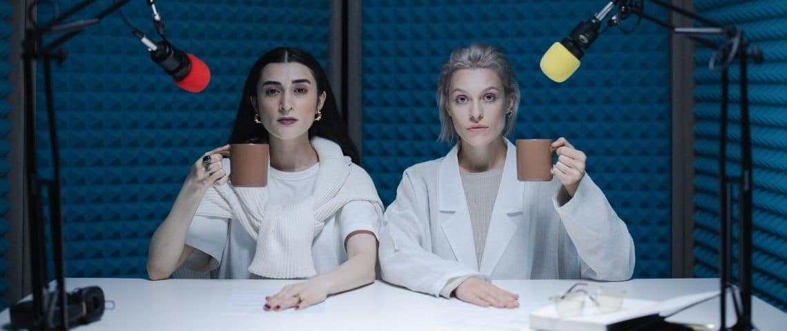 Louie Media et le groupe audiovisuel Mediawan s’associent en vue d’adapter les podcasts de Louie. 2 femmes une tasse à la main dans un studio d'enregistrement