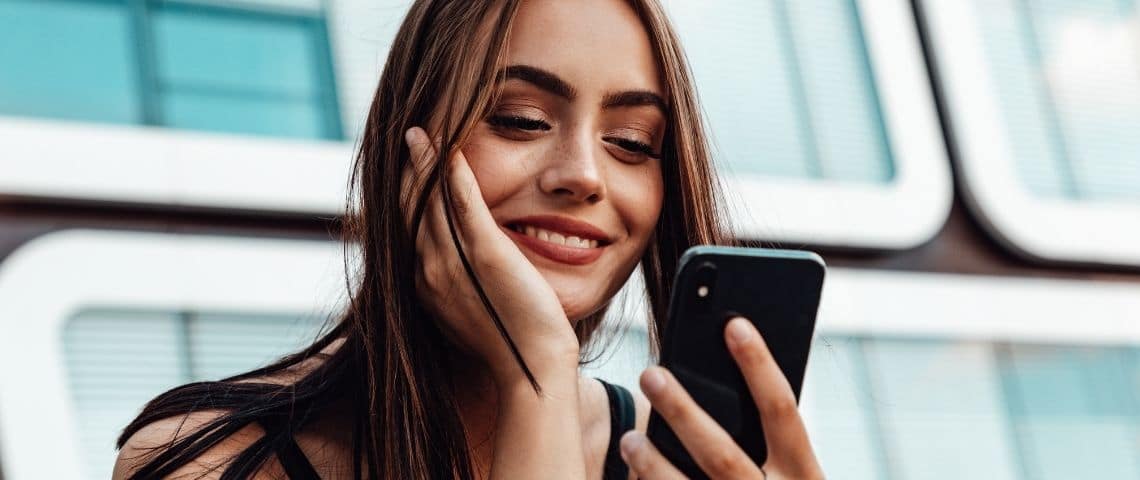 Trois conseils pour booster votre stratégie social media Une femme avec un smartphone