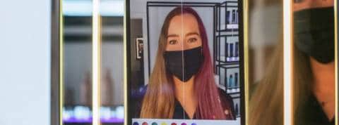 Mais pourquoi Amazon se lance dans la coiffure Une femme devant le miroir connecté du salon de coiffureAmazon