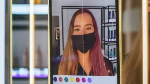 Une femme devant le miroir connecté du salon de coiffureAmazon