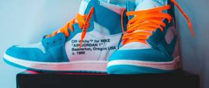 Une paire de baskets Nike bleue turquoise avec des lacets orange